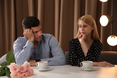 Photo of Displeased man and young woman in restaurant. Failed first date