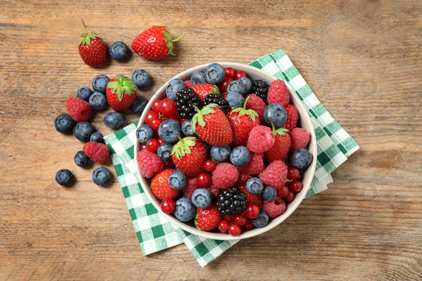 Photo of Mix of ripe berries on wooden table, flat lay