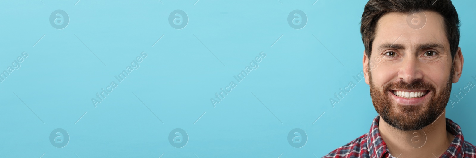 Image of Man with clean teeth smiling on light blue background, space for text. Banner design