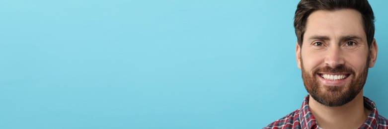 Image of Man with clean teeth smiling on light blue background, space for text. Banner design