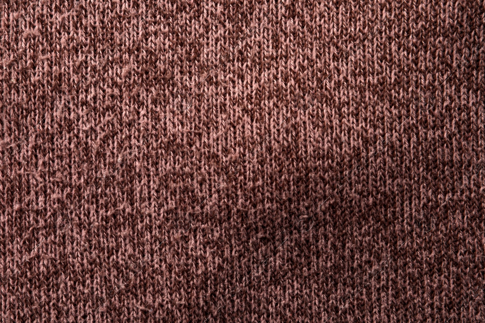 Photo of Knitted cloth with lint as background, top view. Before using of fabric shaver