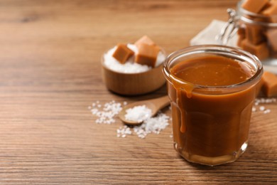 Photo of Tasty salted caramel on wooden table, space for text