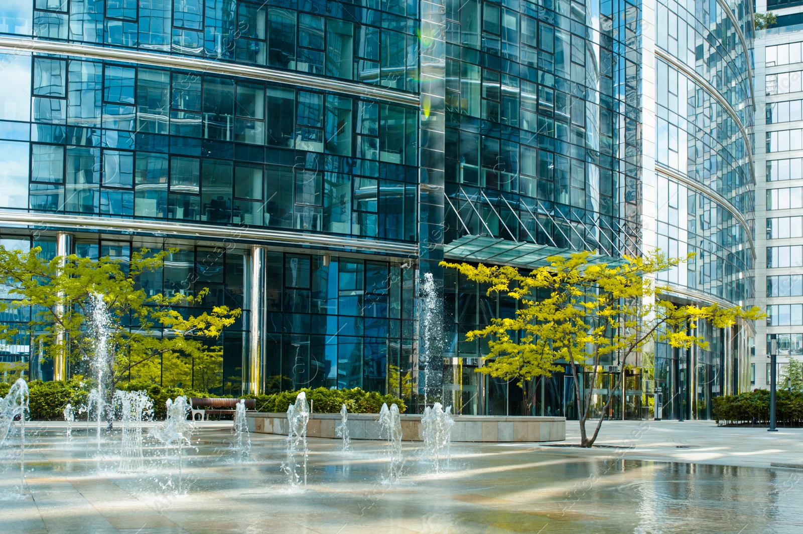 Photo of Beautiful fountains and trees near buildings in city