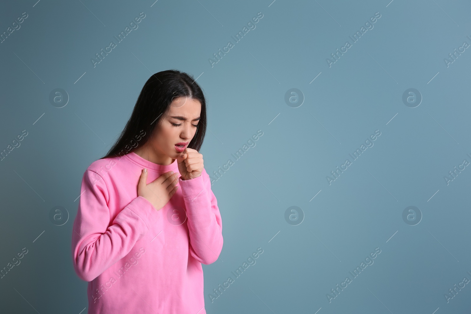 Photo of Young woman coughing on color background