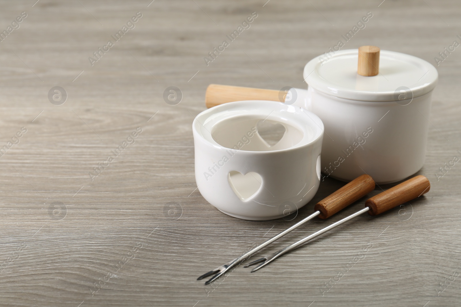 Photo of Fondue set on wooden table, space for text