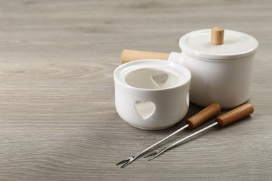 Fondue set on wooden table, space for text