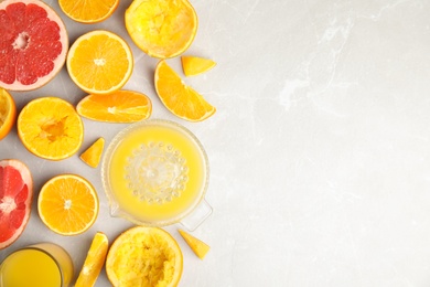 Photo of Flat lay composition with oranges and squeezer on light table. Space for text