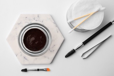 Flat lay composition with eyebrow henna and professional tools on white background