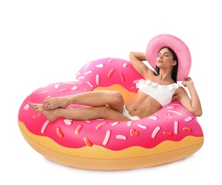 Photo of Beautiful young woman in stylish bikini with hat and inflatable ring on white background