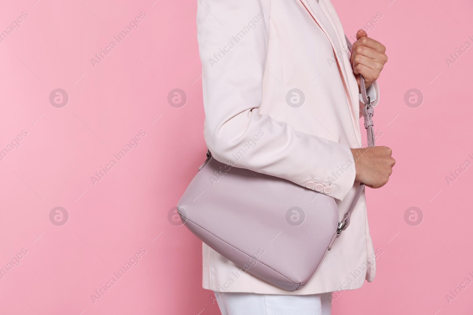 Photo of Woman with stylish bag on pink background, closeup. Space for text