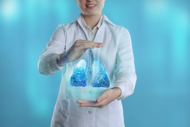 Image of Doctor demonstrating digital image of human lungs on blue background, closeup