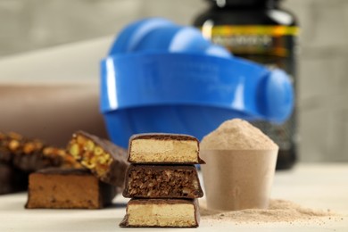 Photo of Different energy bars, protein cocktail and powder on white wooden table, closeup