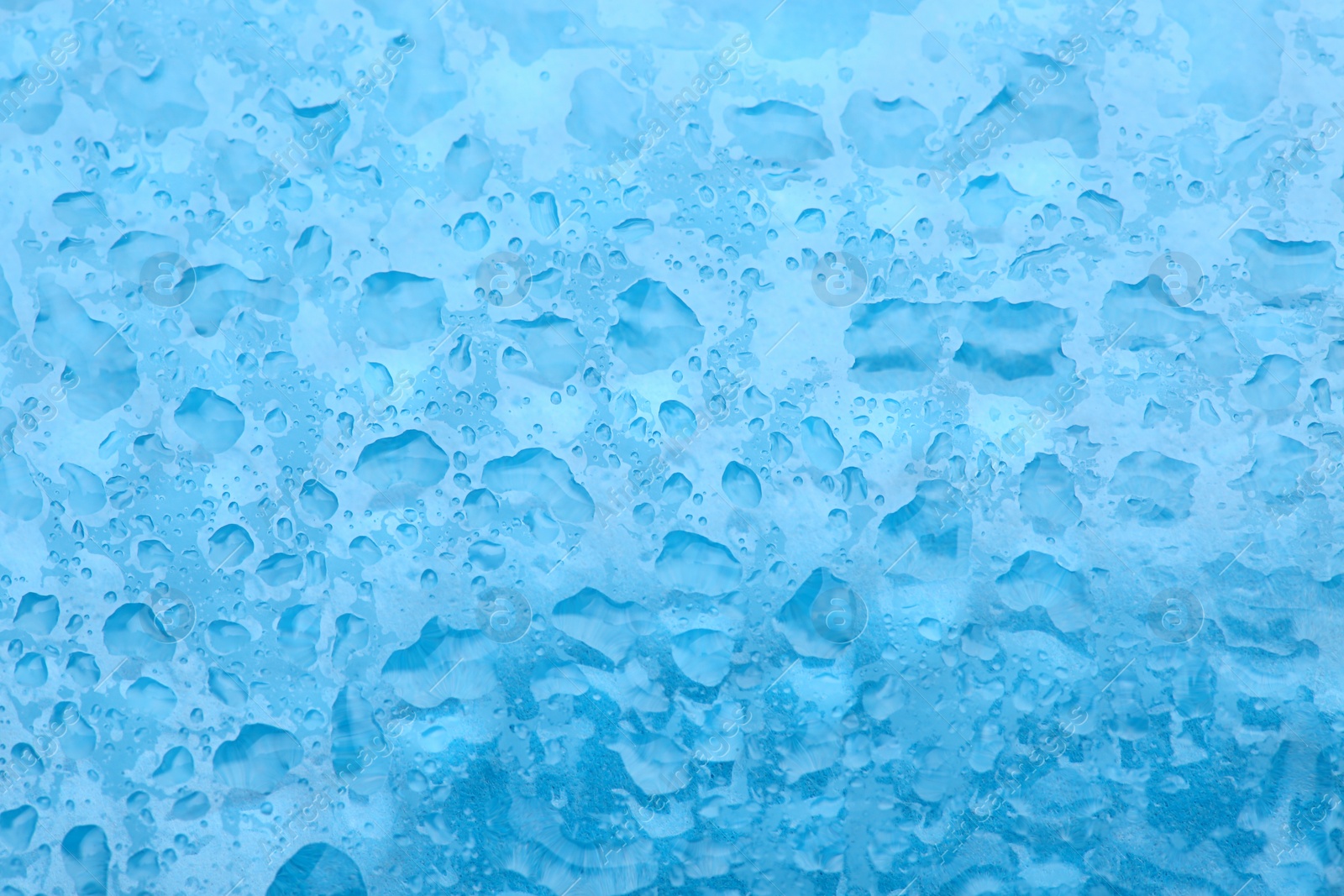 Photo of Water drops on color background, top view