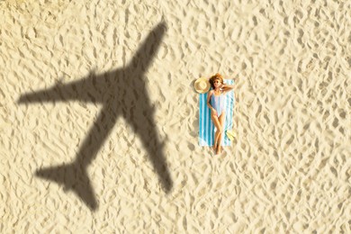 Shadow of airplane and woman sunbathing at sandy beach, aerial view. Summer vacation
