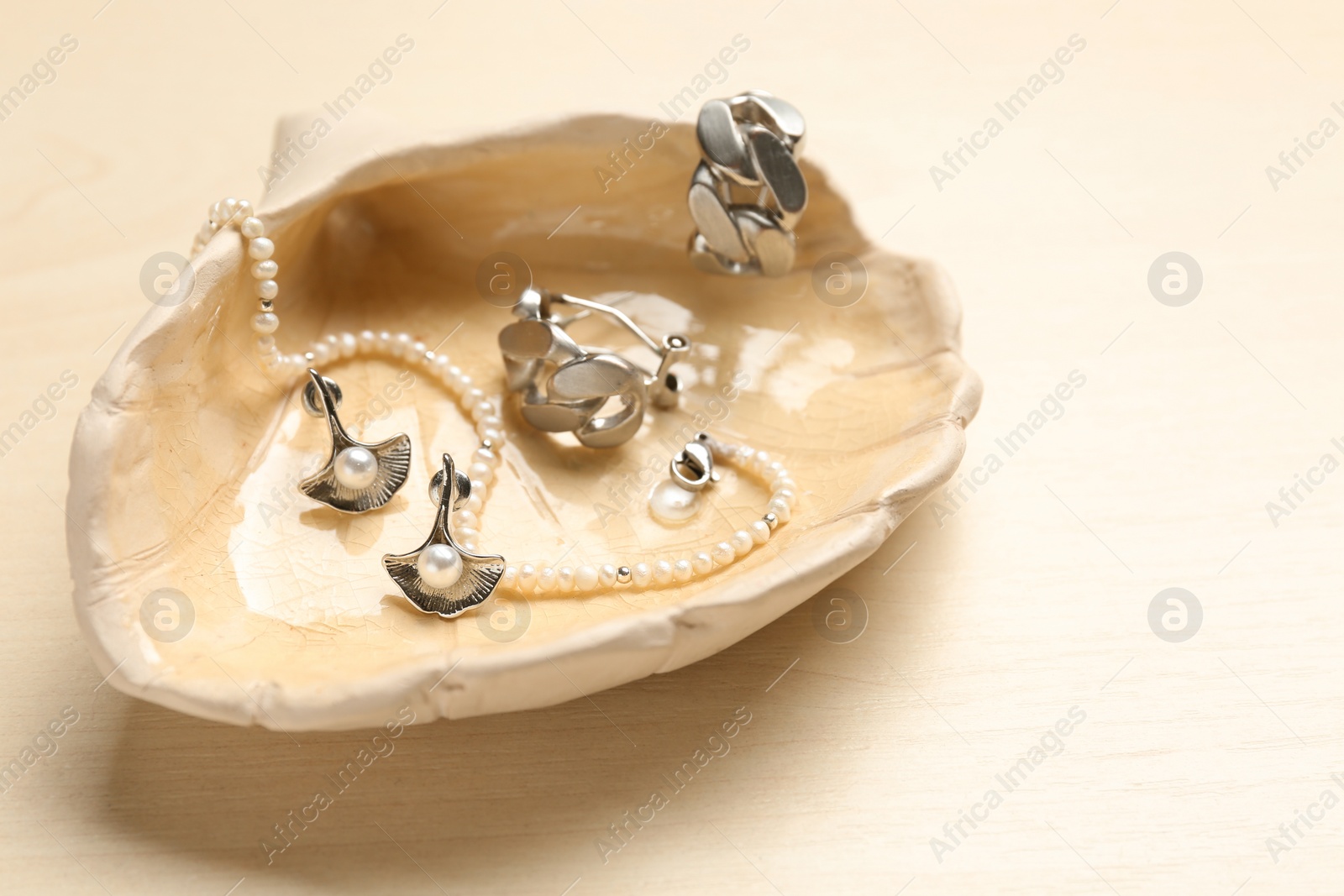 Photo of Beautiful seashell with luxury jewelry on wooden background