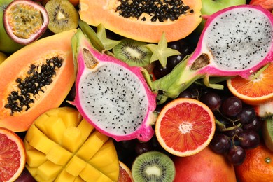 Many different delicious exotic fruits as background, top view