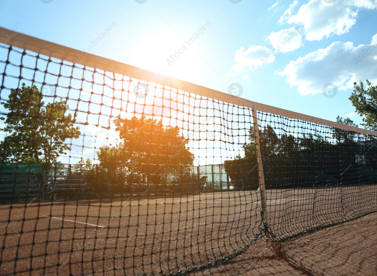 Photo of Tennis court with net on sunny day