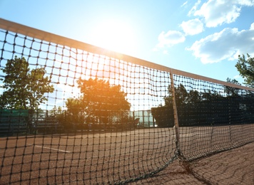 Photo of Tennis court with net on sunny day