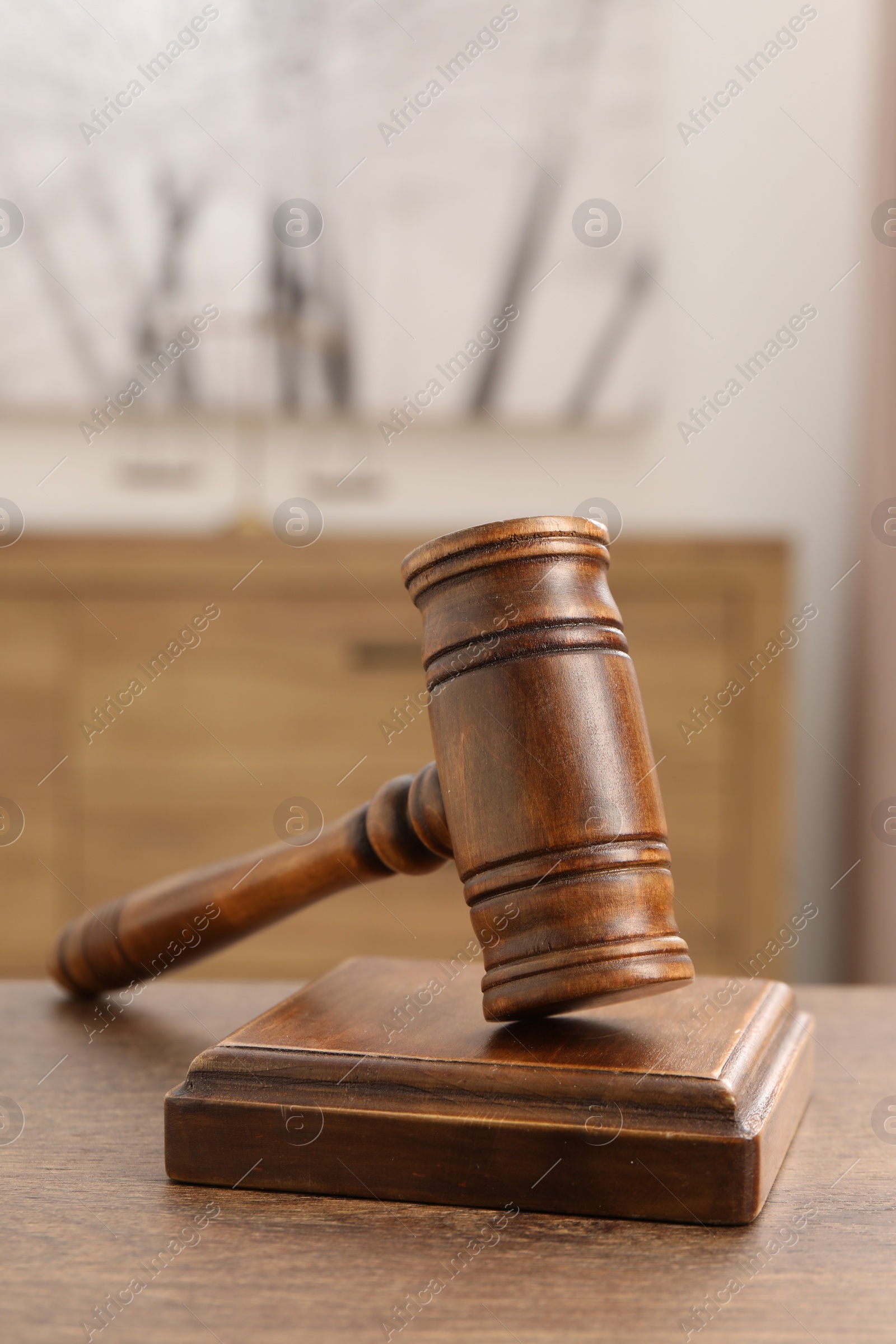 Photo of Wooden gavel and sound block on table indoors, closeup. Space for text