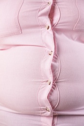 Overweight woman in tight shirt, closeup. Obesity and weight loss