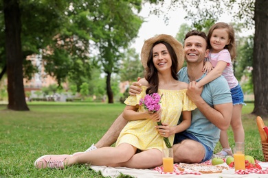 Happy family having picnic in park on summer day