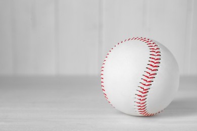 Baseball ball on white table, closeup. Space for text