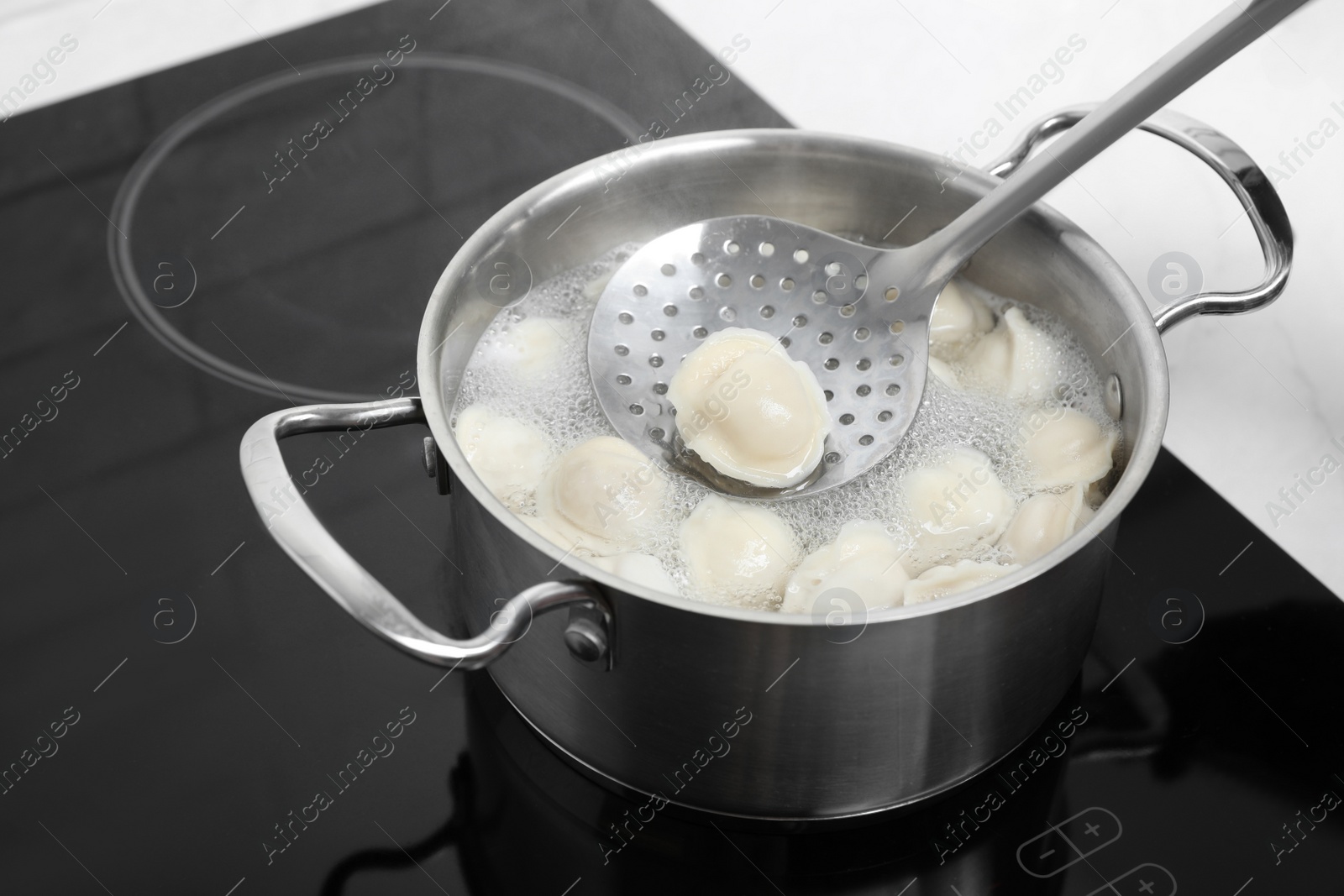 Photo of Woman cooking delicious dumplings in kitchen, closeup