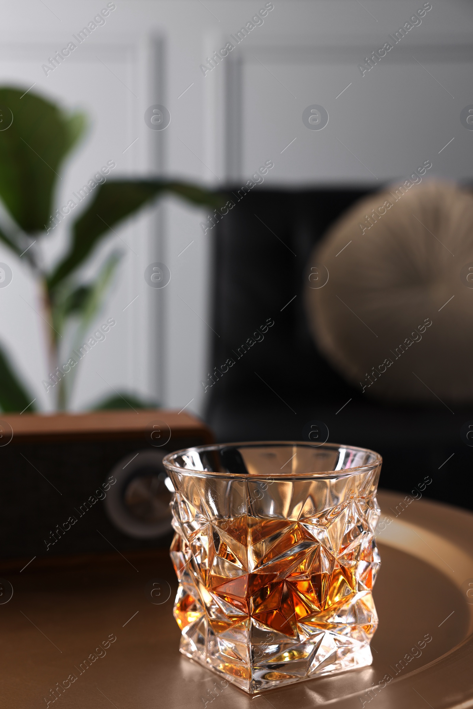 Photo of Alcohol drink on golden table in room, space for text. Relax at home