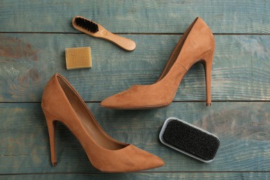 Photo of Stylish footwear with shoe care accessories on light blue wooden table, flat lay