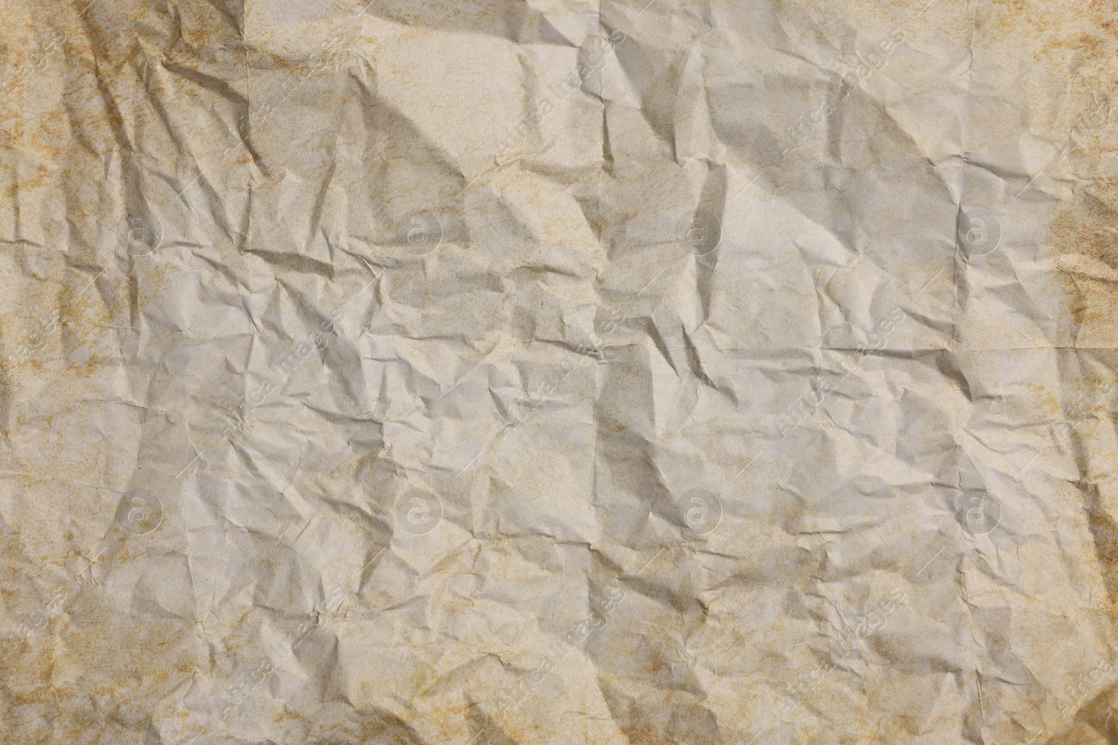 Photo of Texture of crumpled parchment paper as background, top view