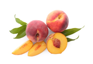 Whole and cut ripe peaches with leaves isolated on white, top view