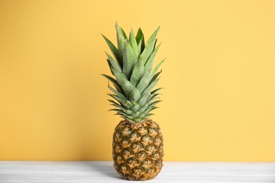 Photo of Fresh ripe juicy pineapple on white wooden table