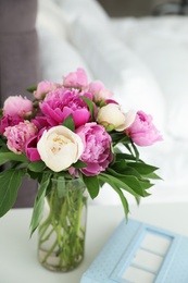 Photo of Vase with bouquet of beautiful peonies on table in room