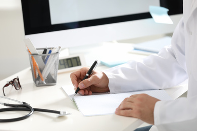 Photo of Doctor working at desk in office, closeup