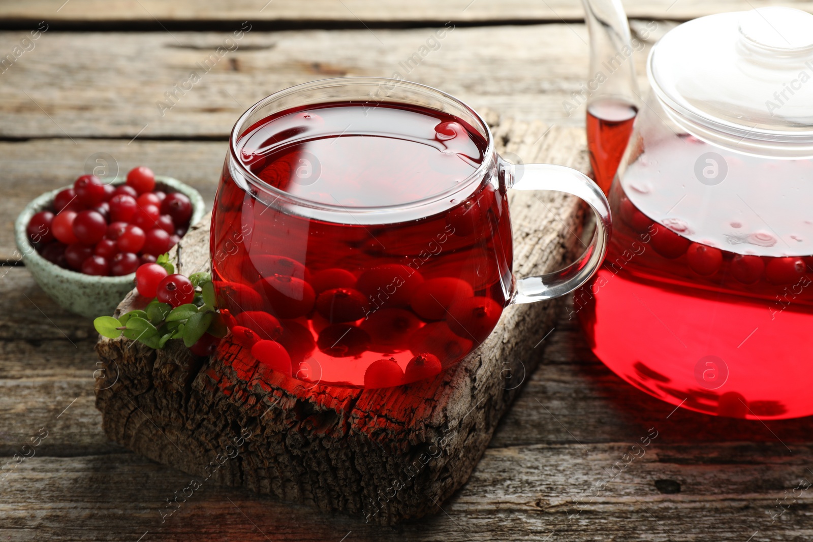 Photo of Delicious cranberry tea and berries on wooden table