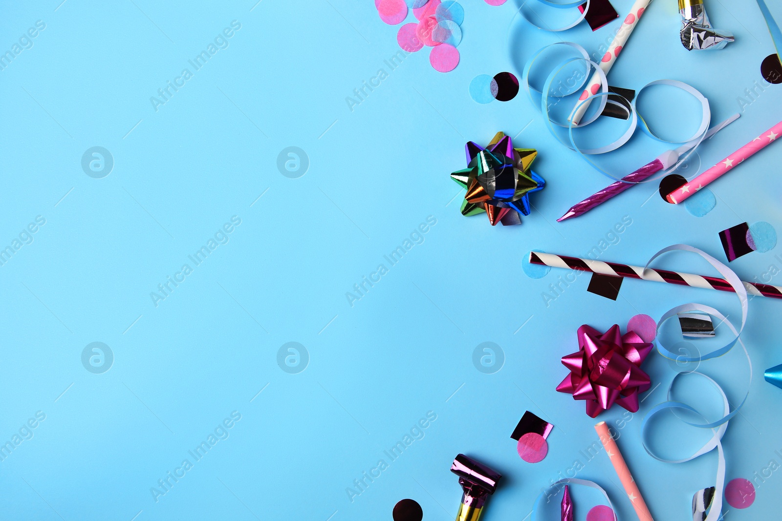 Photo of Different colorful festive decor on light blue background, flat lay. Space for text