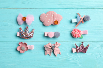 Photo of Cute hair clips on light blue wooden table, flat lay