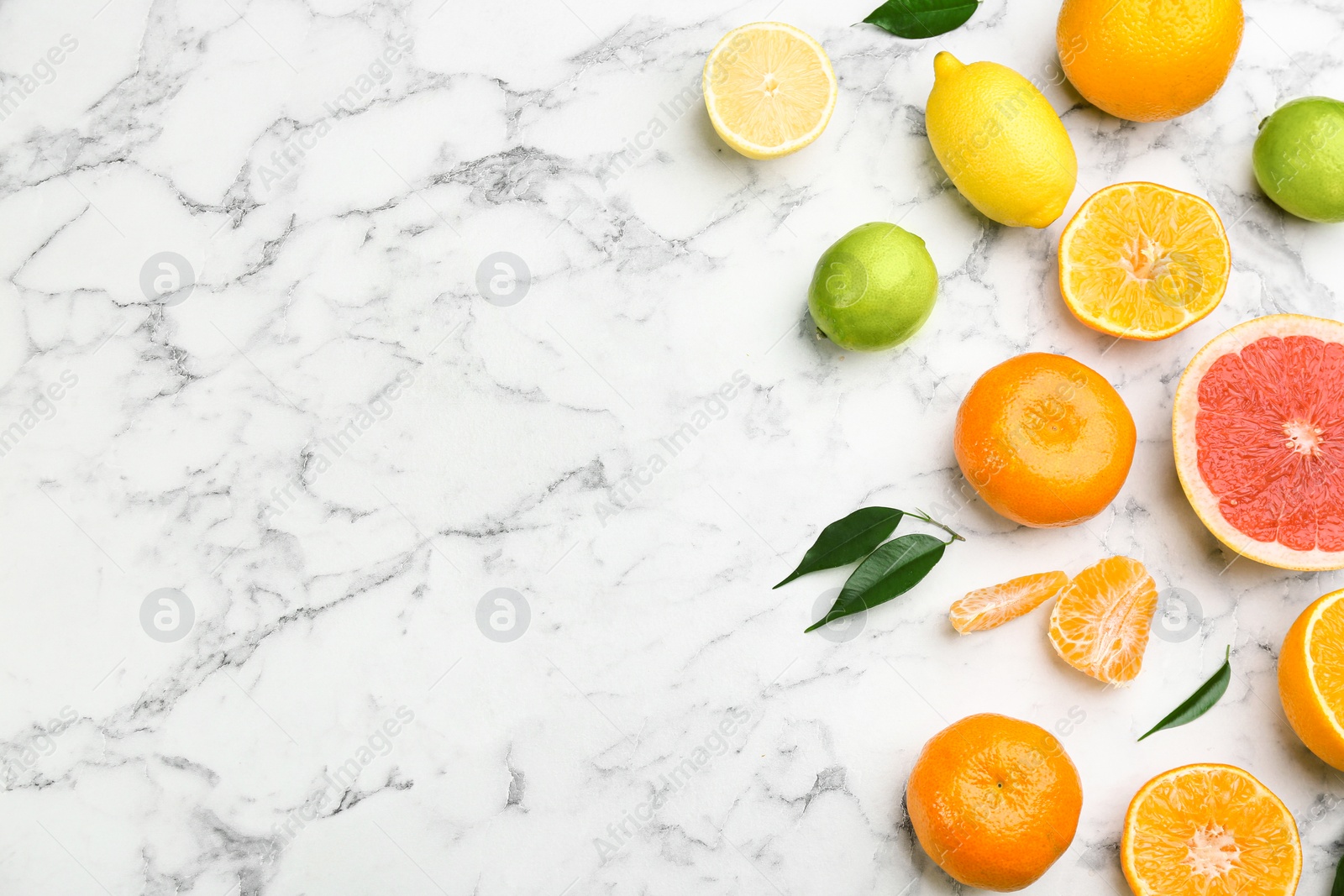 Photo of Flat lay composition with tangerines and different citrus fruits on white marble background. Space for text