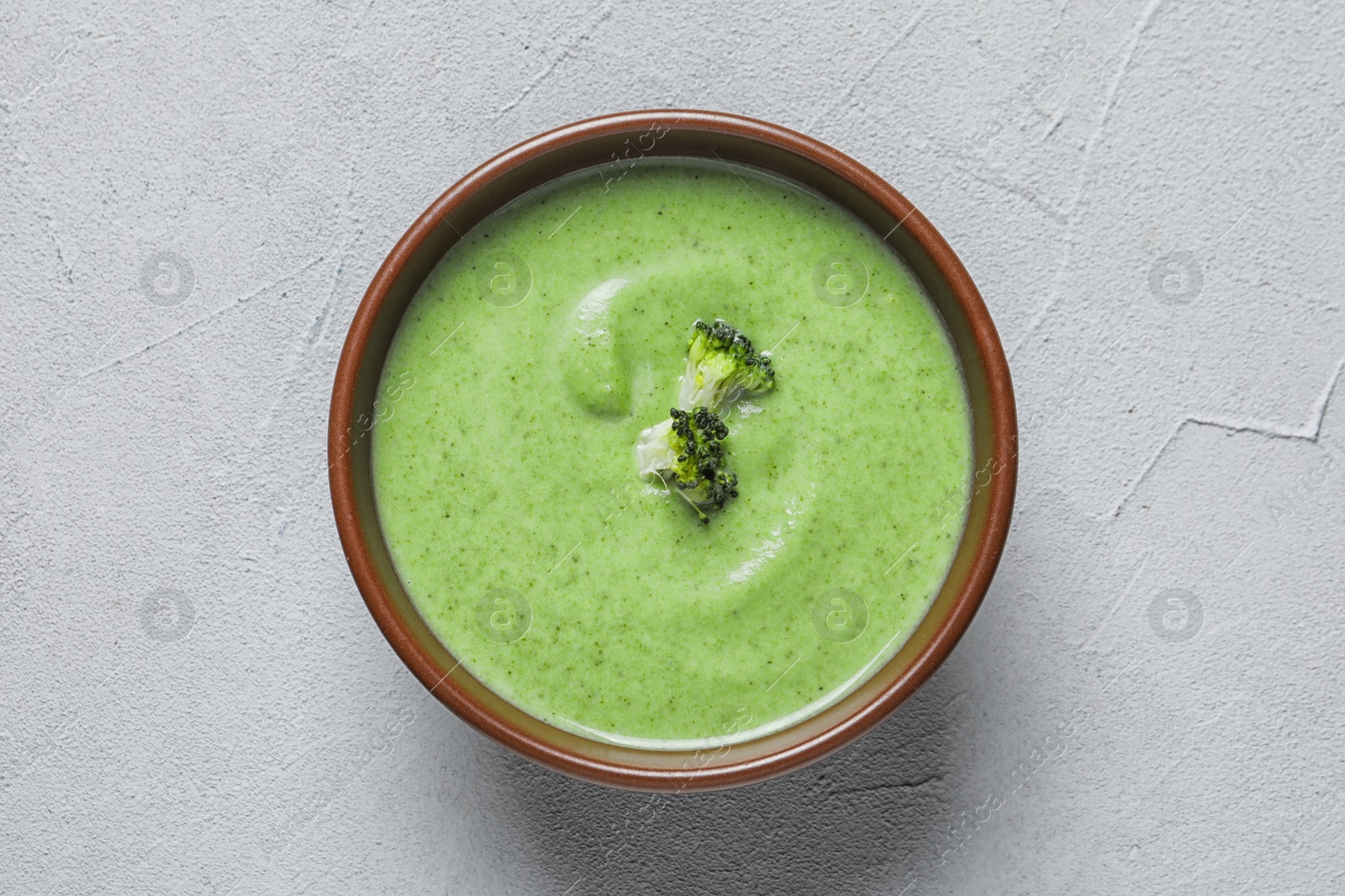 Photo of Fresh vegetable detox soup made of broccoli in dish on table, top view