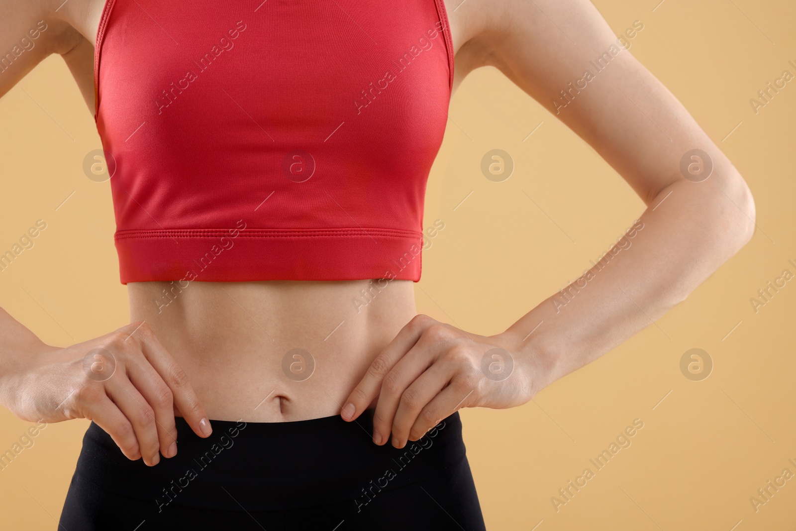 Photo of Young woman in sportswear on beige background, closeup