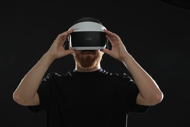 Photo of Man using virtual reality headset on black background
