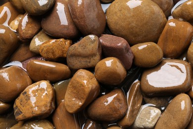 Beautiful pebbles in water as background, top view