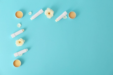 Photo of Flat lay composition with hygienic lipsticks and balms on color background