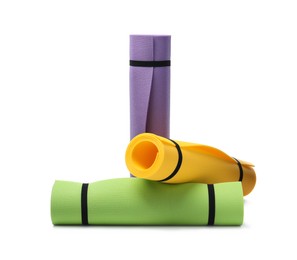 Photo of Colorful rolled camping or exercise mats on white background