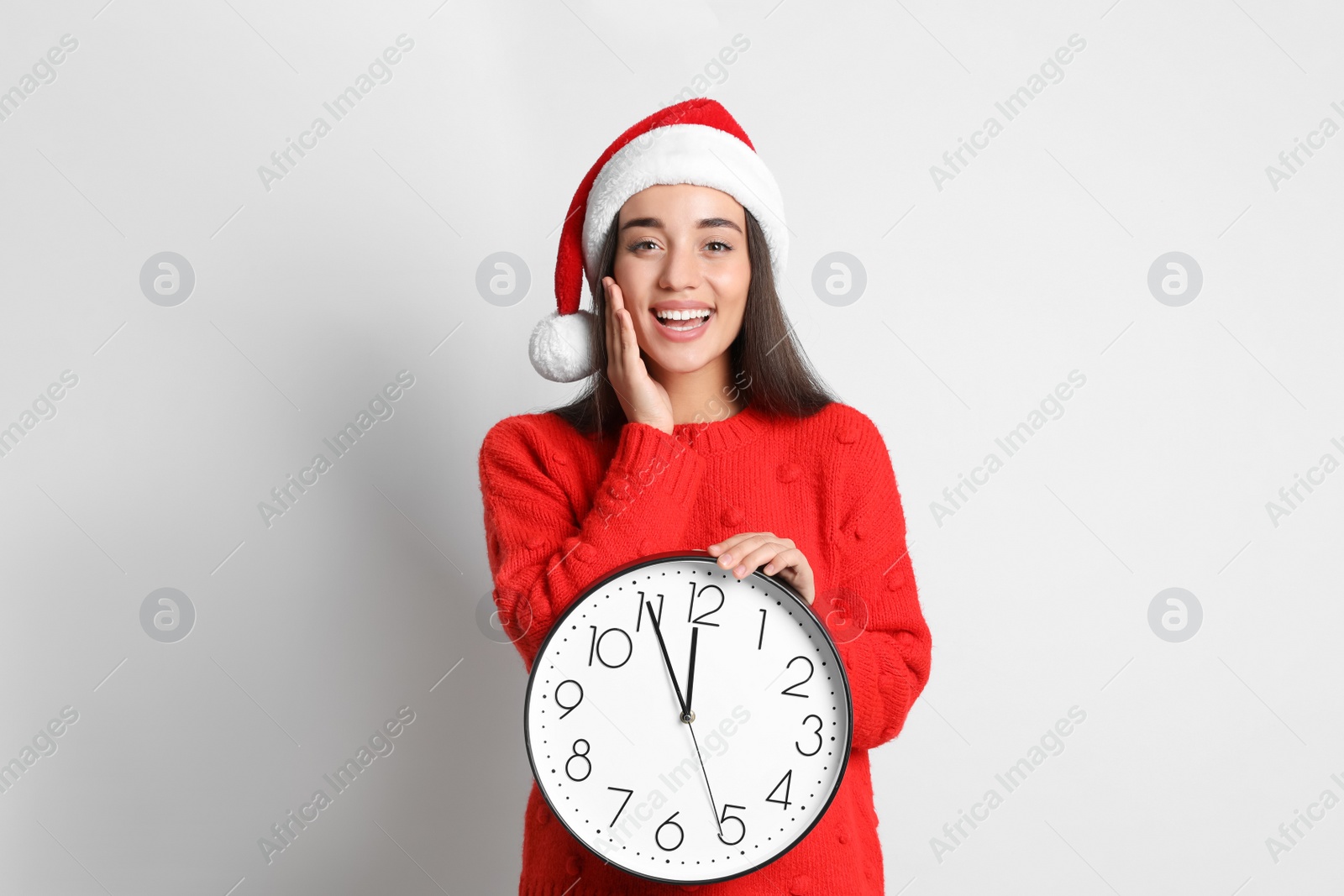 Photo of Woman in Santa hat with clock on white background. Christmas countdown