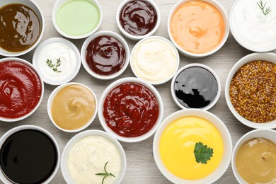 Photo of Many different sauces on white wooden table, flat lay