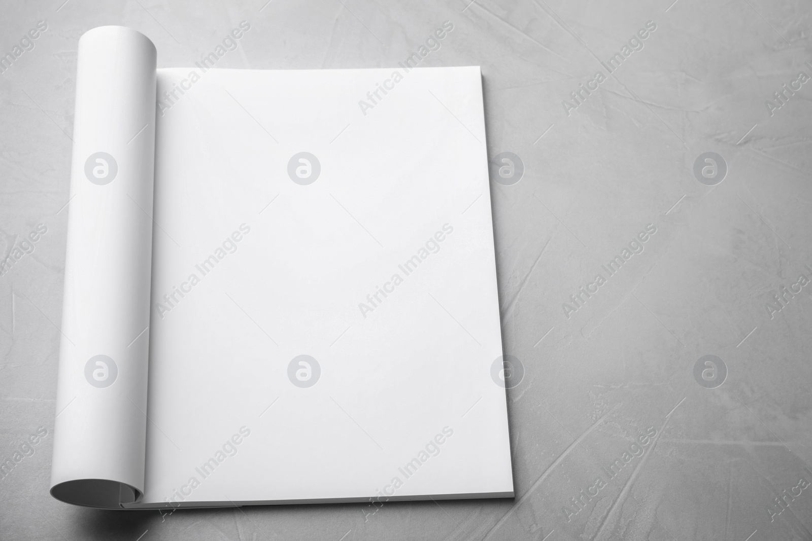 Photo of Blank open book on light grey stone background. Mock up for design