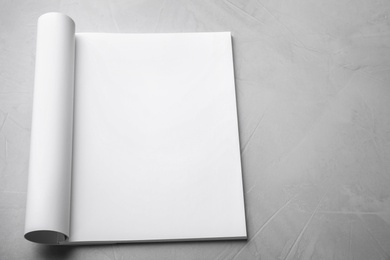 Blank open book on light grey stone background. Mock up for design