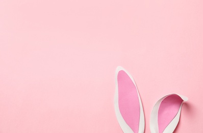 Funny Easter bunny ears on color background, top view with space for text