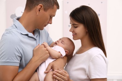 Happy family with their sleeping baby on blurred background